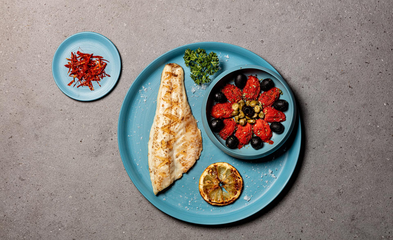 Filetto di branzino con pomodorini, olive e capperi