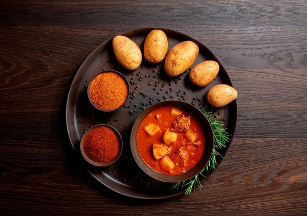 Gulaschsuppe mit Kartoffeldekoration, Gewürzschüsseln und Rosmarin