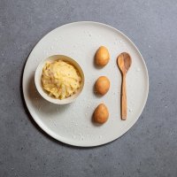 Potatoes in teak with whole potato decoration and wooden spoon